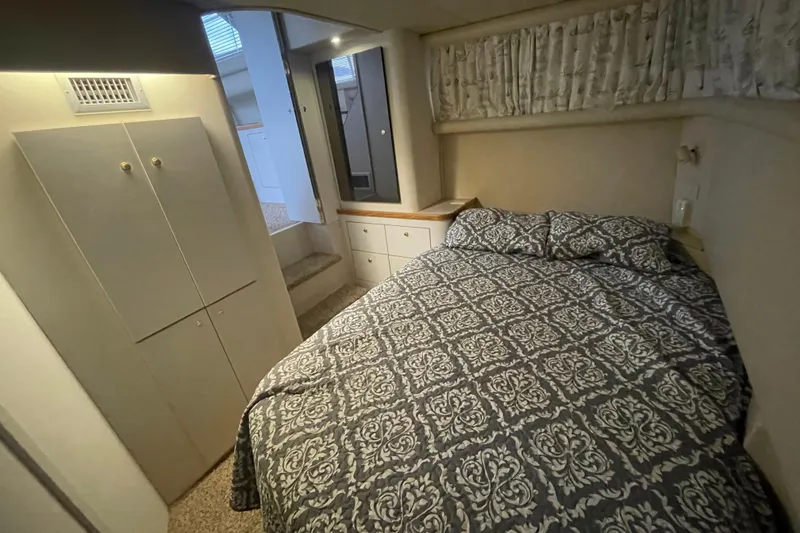 Slide: The Image of 1997 Cruisers Yachts 3650 Aft Cabin bedroom with patterned bedding and storage cabinets. - 31