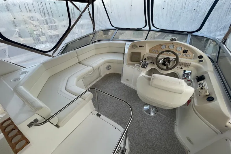 Slide: The Image of 1997 Cruisers Yachts 3650 Aft Cabin helm with white seating and control panel. - 7