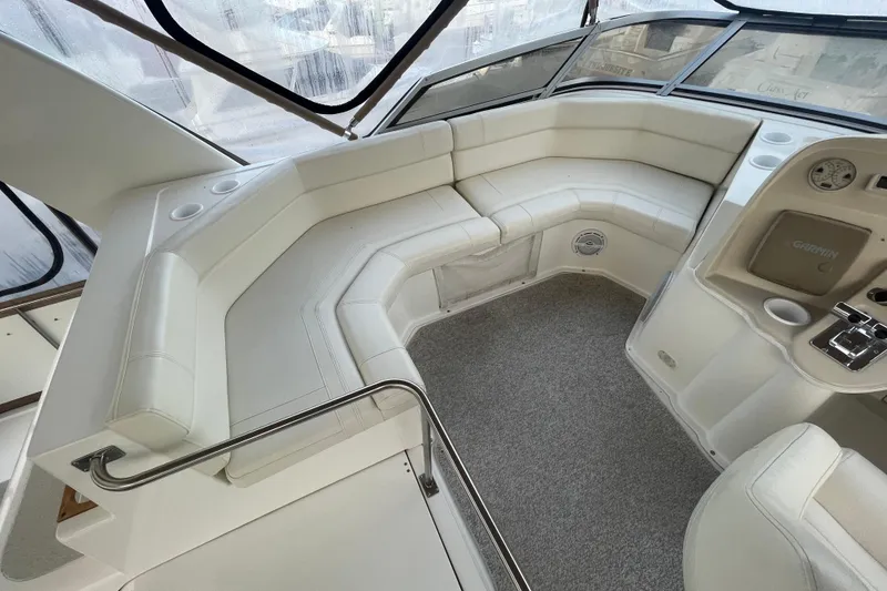 Slide: The Image of 1997 Cruisers Yachts 3650 Aft Cabin interior with white seating and helm controls. - 9