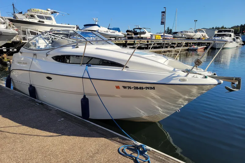 The Image of 2003 Bayliner 245 boat docked at marina, sunny day, calm water. - 0