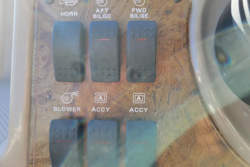 Slide: The Image of Control panel of a 2003 Bayliner 245 boat with switches for horn, bilge, and blower. - 13
