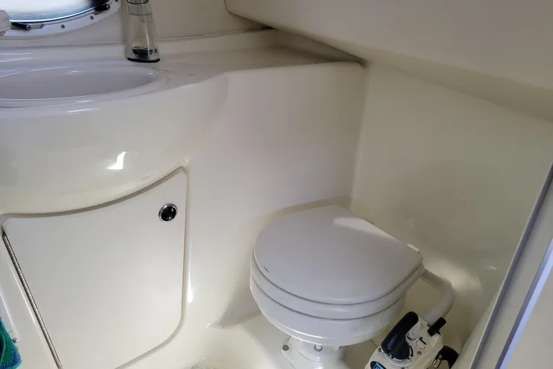 Slide: The Image of Compact bathroom in 2003 Bayliner 245 boat with toilet and sink. - 28