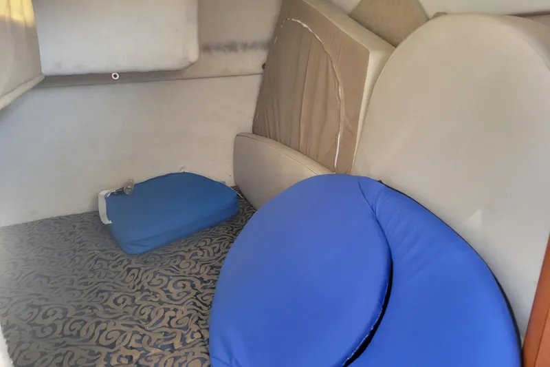 Slide: The Image of Interior cabin of a 2003 Bayliner 245 boat with cushions and patterned flooring. - 30