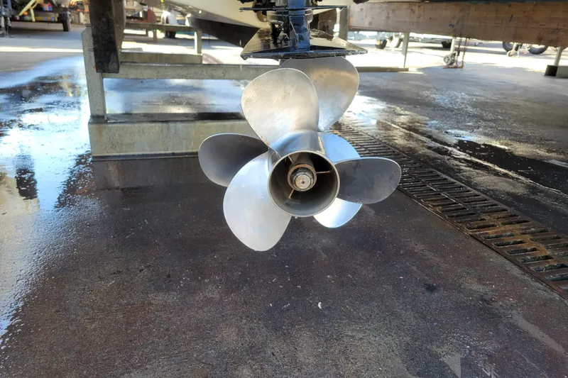 Slide: The Image of Propeller of a 2003 Bayliner 245 boat on a wet dock surface. - 38