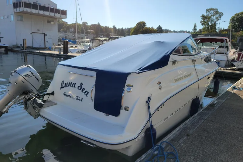 Slide: The Image of 2003 Bayliner 245 boat docked, covered with blue tarp, featuring Honda outboard motor. - 39