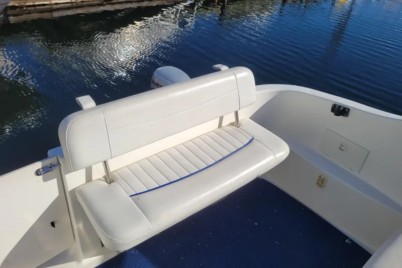 Slide: The Image of 2003 Bayliner 245 boat interior with white seating by the water. - 6