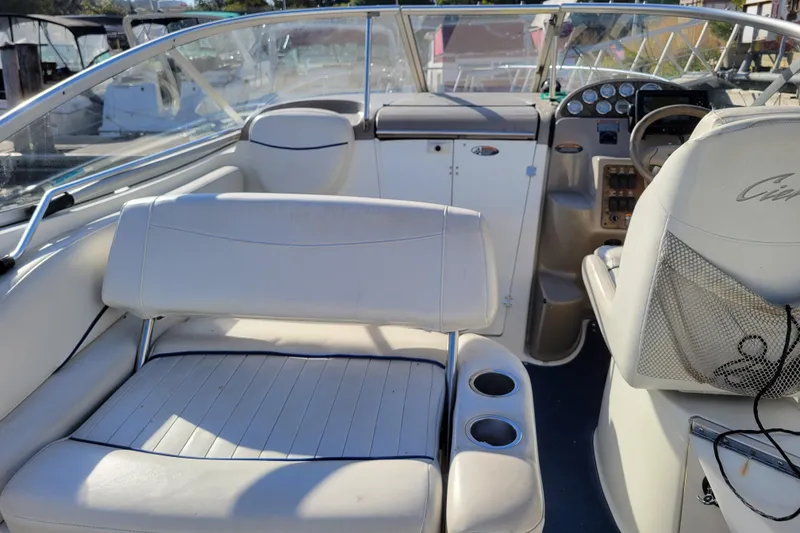 Slide: The Image of 2003 Bayliner 245 boat interior with white seating and dashboard controls. - 7
