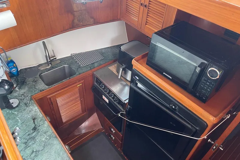 Slide: The Image of 2005 Mariner 38 Orient boat helm with navigation equipment and wooden steering wheel. - 15