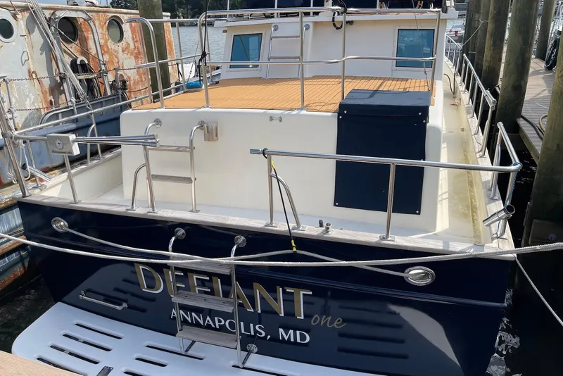 Slide: The Image of Flybridge of 2005 Mariner 38 Orient yacht with seating and steering wheel, docked at marina. - 2