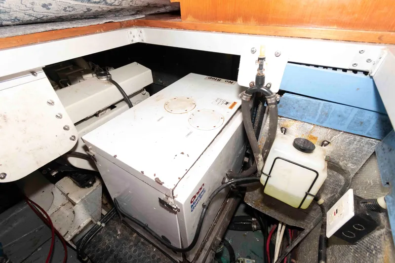 Slide: The Image of Engine compartment of 2005 Mariner 38 Orient boat, featuring mechanical components and storage. - 25