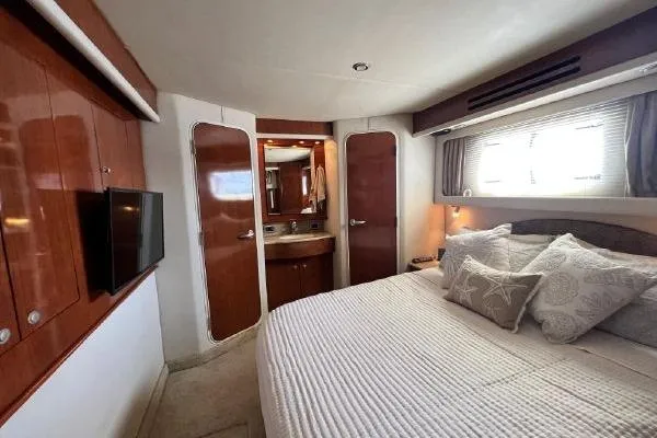 Slide: The Image of Luxurious 2004 Sea Ray 390 Motor Yacht bedroom with elegant wood finishes and cozy bedding. - 17