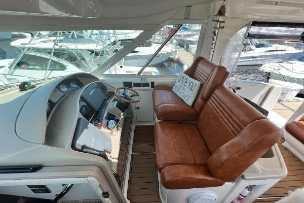 Slide: The Image of 2004 Sea Ray 390 Motor Yacht helm with leather seating and marina view. - 8