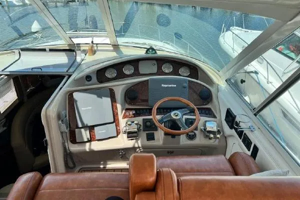 Slide: The Image of 2004 Sea Ray 390 Motor Yacht helm with leather seating and navigation controls. - 9