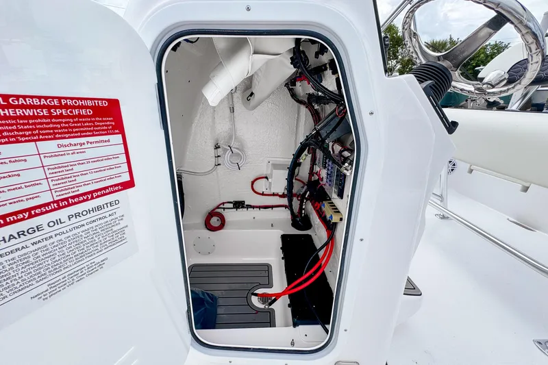 Slide: The Image of 2026 Tidewater 2110 Bay Max boat interior wiring and storage compartment. - 11