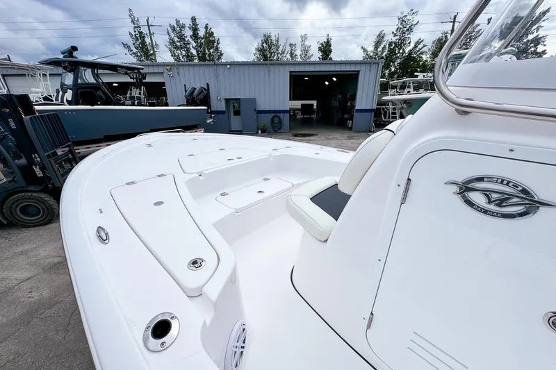 Slide: The Image of 2026 Tidewater 2110 Bay Max boat, white deck, near a workshop under cloudy skies. - 13