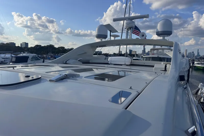 Slide: The Image of 2006 Azimut 68S yacht docked, showcasing sleek design under a partly cloudy sky. - 11