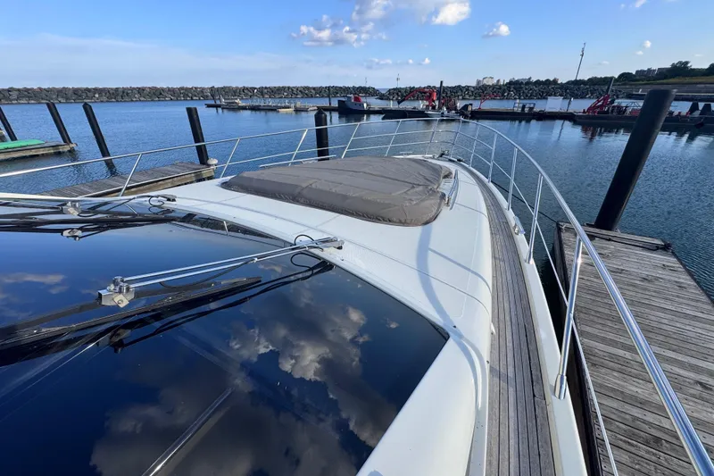 Slide: The Image of 2006 Azimut 68S yacht docked at marina, reflecting blue sky and clouds. - 12
