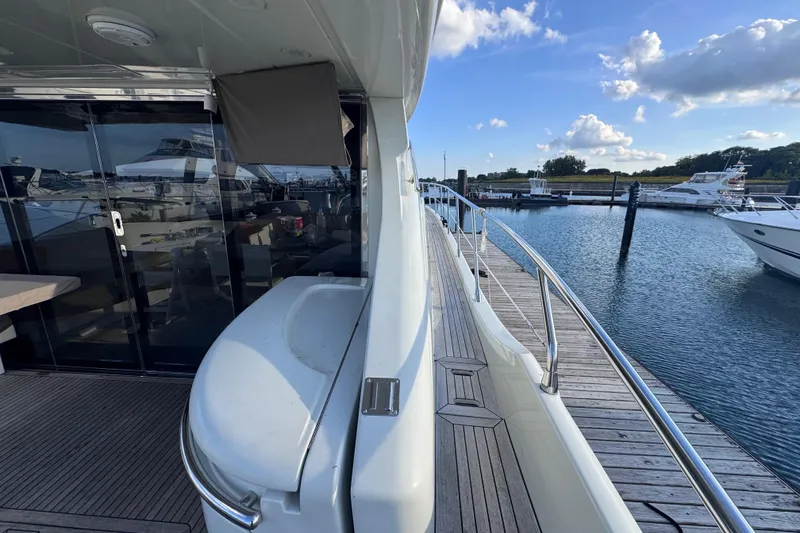 Slide: The Image of 2006 Azimut 68S yacht docked at marina, showcasing sleek design and spacious deck. - 13