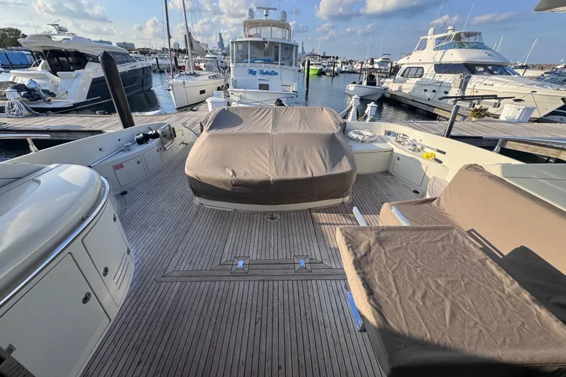 Slide: The Image of 2006 Azimut 68S yacht docked at marina, featuring spacious deck and covered seating area. - 16