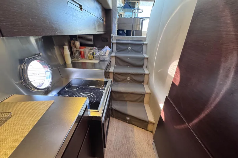 Slide: The Image of Compact kitchen area in 2006 Azimut 68S yacht with modern appliances and stairs. - 43