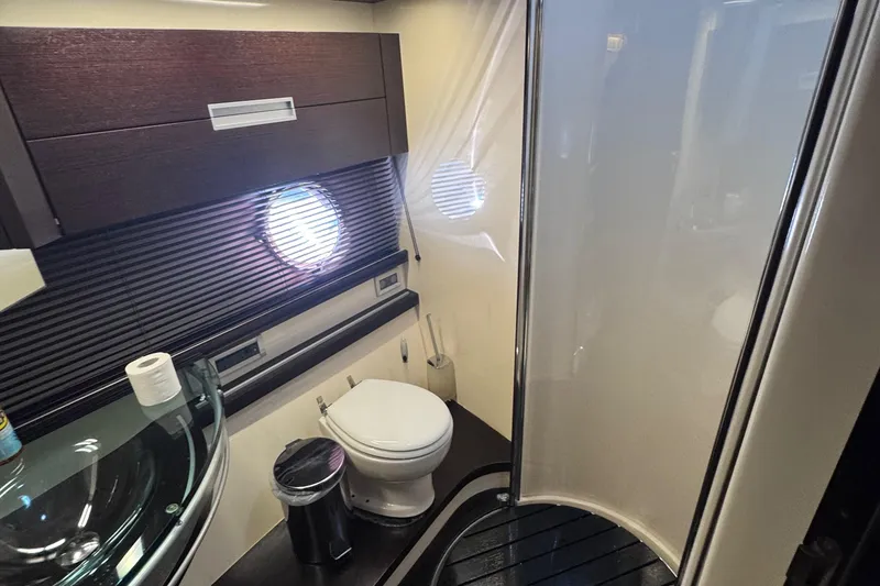 Slide: The Image of Luxurious bathroom in a 2006 Azimut 68S yacht with modern fixtures and porthole window. - 54