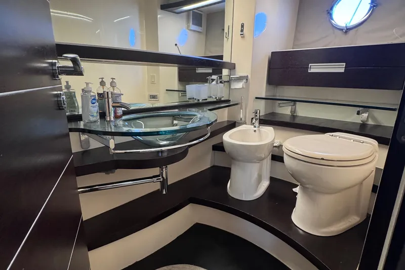 Slide: The Image of Luxurious bathroom in a 2006 Azimut 68S yacht with modern fixtures and glass sink. - 78