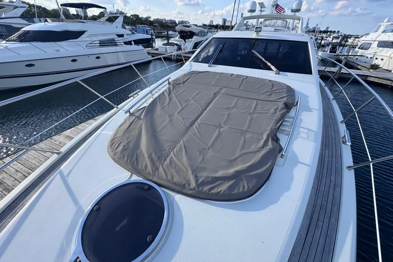 Slide: The Image of 2006 Azimut 68S yacht docked at marina, featuring sleek design and sunbathing area. - 9