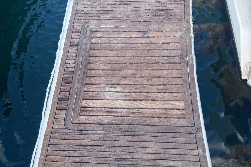 Slide: The Image of Wooden deck of a 2006 Azimut 68S yacht by the water. - 90