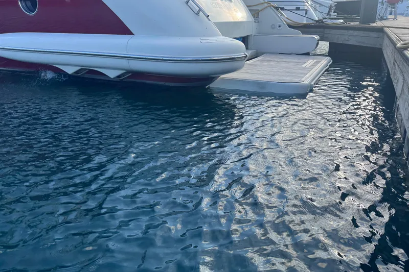 Slide: The Image of Azimut 68S yacht from 2006 docked at marina, reflecting on water. - 92