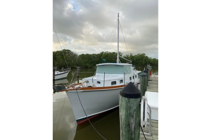 The Image of 1963 Wiley Trawler docked at a marina, featuring classic design and green canopy. - 0