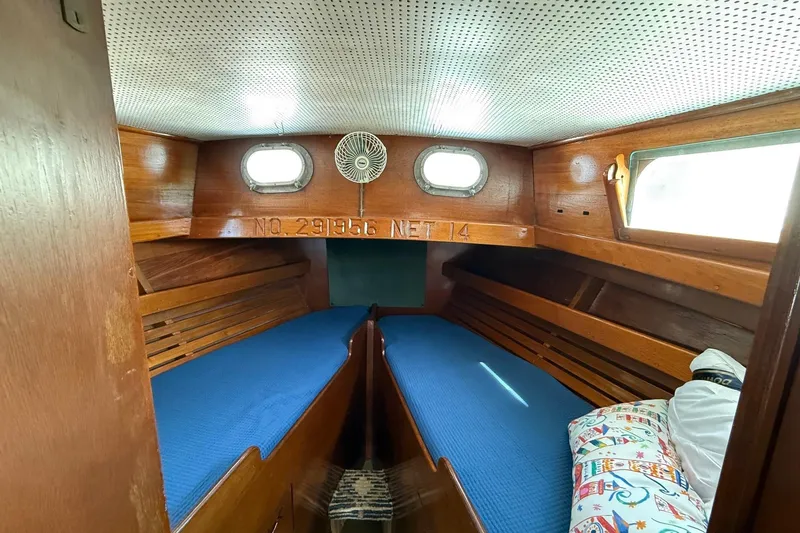 Slide: The Image of Cozy cabin interior of a 1963 Wiley Trawler with wooden finish and blue bedding. - 29
