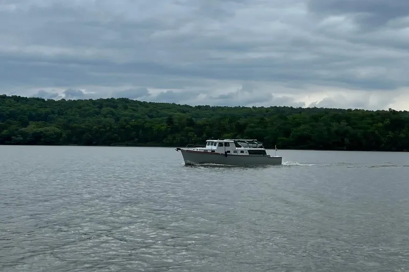 Slide: The Image of 1963 Wiley Trawler cruising on a calm lake with forested shoreline. - 33