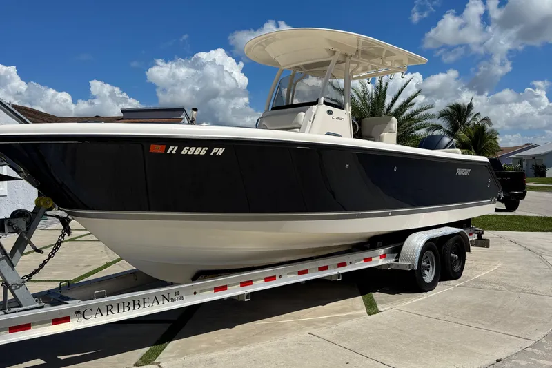 Slide: The Image of 2012 Pursuit C 260 Center Console boat on trailer, parked in sunny driveway. - 1
