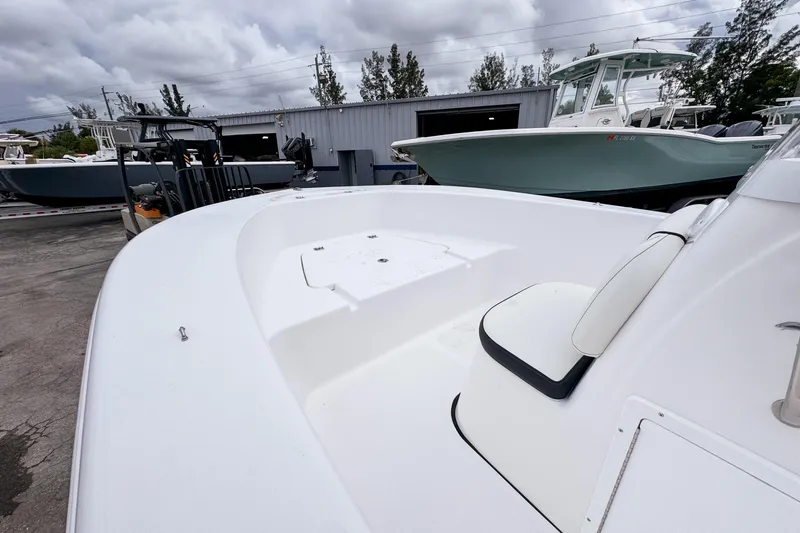 Slide: The Image of 2026 Tidewater 180 CC Adventure boat, white deck, parked outdoors under cloudy sky. - 12