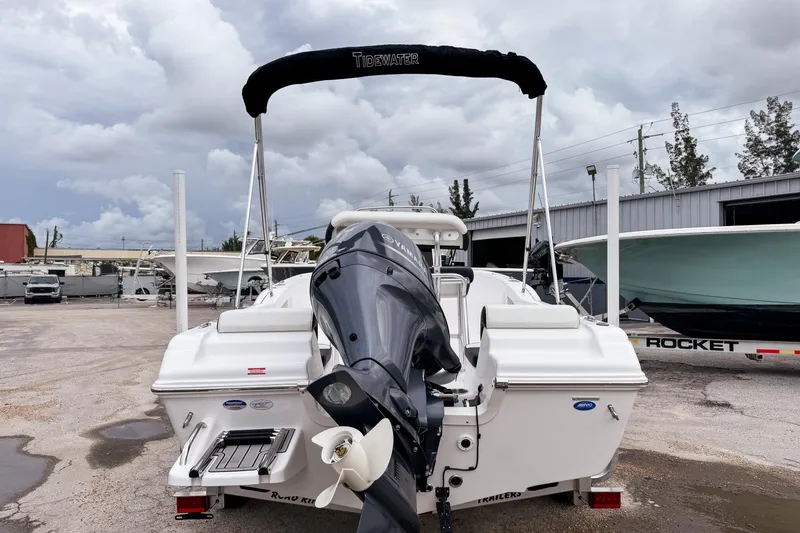Slide: The Image of 2026 Tidewater 180 CC Adventure boat with outboard motor, parked outdoors under cloudy skies. - 6