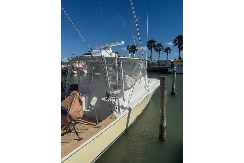 Slide: The Image of 1983 Hines-Farley 34 Express boat docked in sunny marina with palm trees. - 9