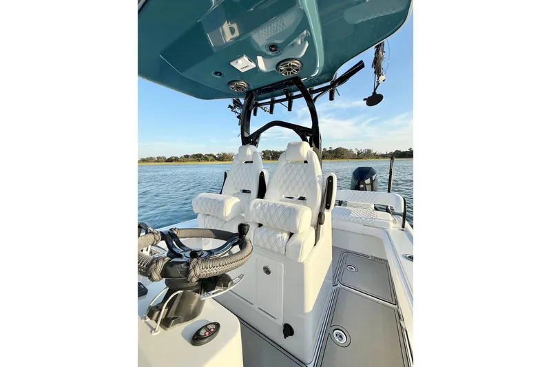 Slide: The Image of 2025 Costa Custom Boats 264 HC on water, featuring dual engines and cushioned seating. - 17