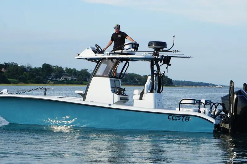 Slide: The Image of 2025 Costa Custom Boats 264 HC cruising on a river with lush greenery in the background. - 7