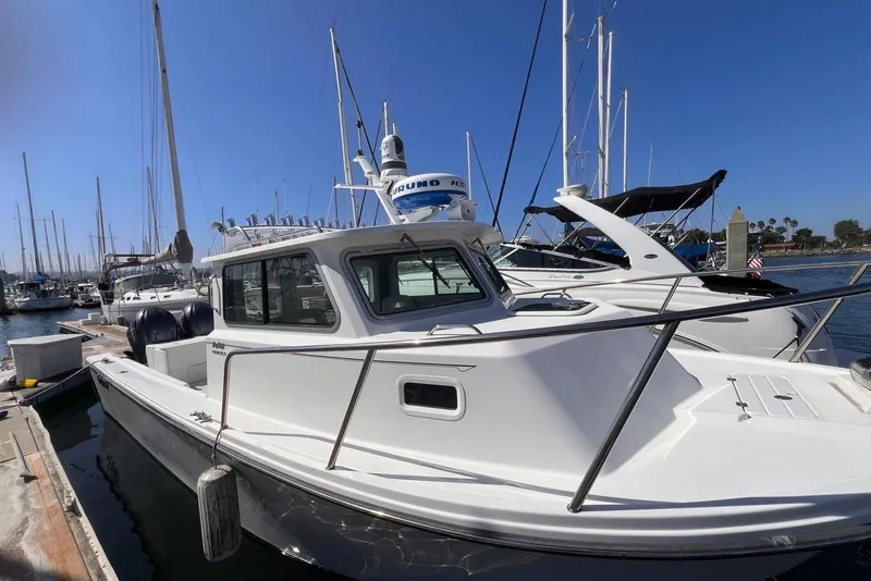 Slide: The Image of 2023 Parker 2820 XLD Sport Cabin boat docked at marina with clear blue sky. - 2