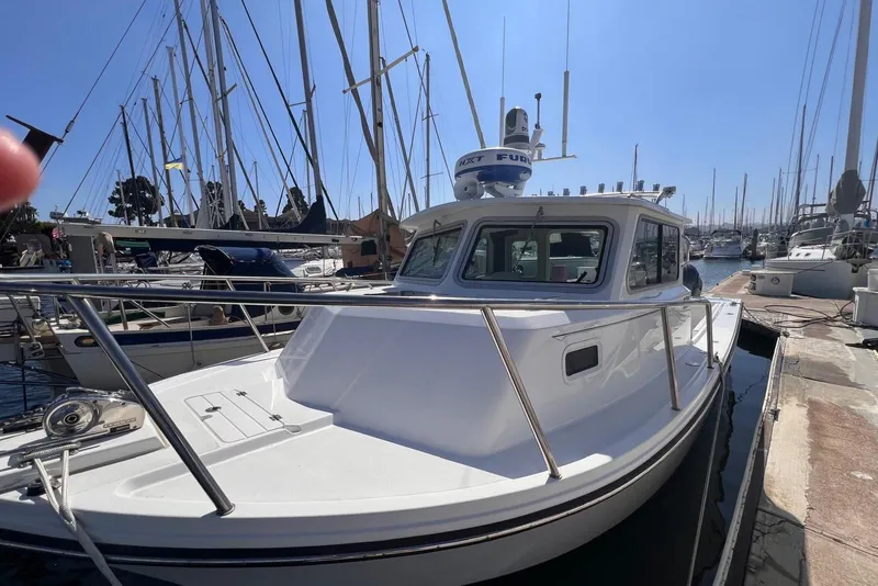 Slide: The Image of 2023 Parker 2820 XLD Sport Cabin boat docked at marina, surrounded by sailboats. - 3