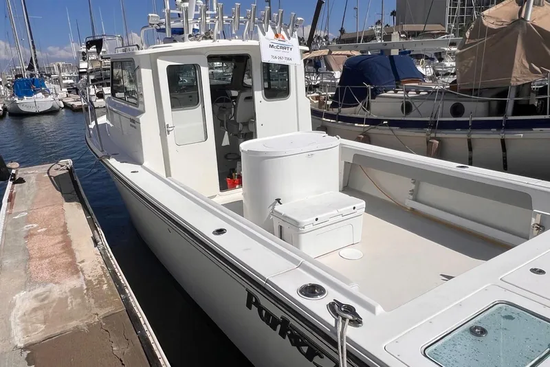 Slide: The Image of 2023 Parker 2820 XLD Sport Cabin boat docked at marina, featuring spacious deck and cabin. - 4