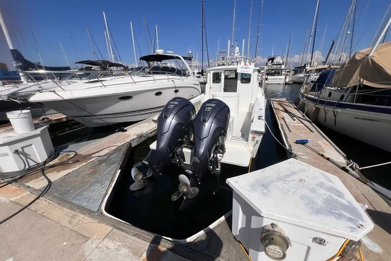Slide: The Image of 2023 Parker 2820 XLD Sport Cabin boat docked with twin outboard engines. - 6