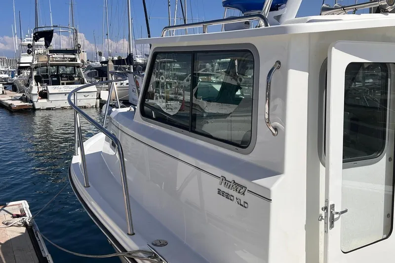 Slide: The Image of 2023 Parker 2820 XLD Sport Cabin boat docked at marina, side view. - 8