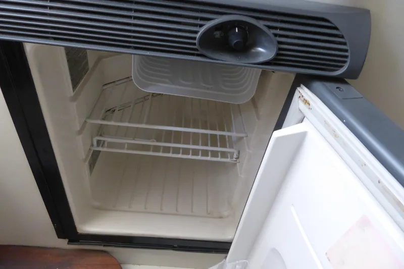 Slide: The Image of Open refrigerator inside 2006 Hydra-Sports Vector 2900 VX boat, showing empty shelves. - 20