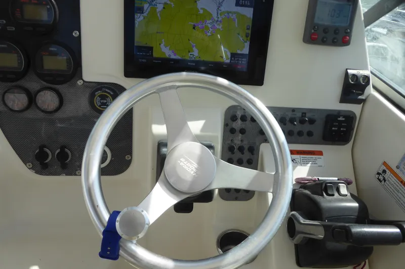 Slide: The Image of 2006 Hydra-Sports Vector 2900 VX helm with steering wheel, navigation screen, and control panel. - 24