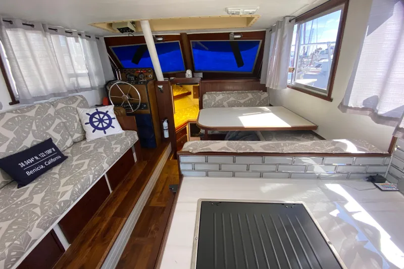 Slide: The Image of 1976 Uniflite Sport Flybridge interior with seating, table, and helm, featuring nautical decor. - 10