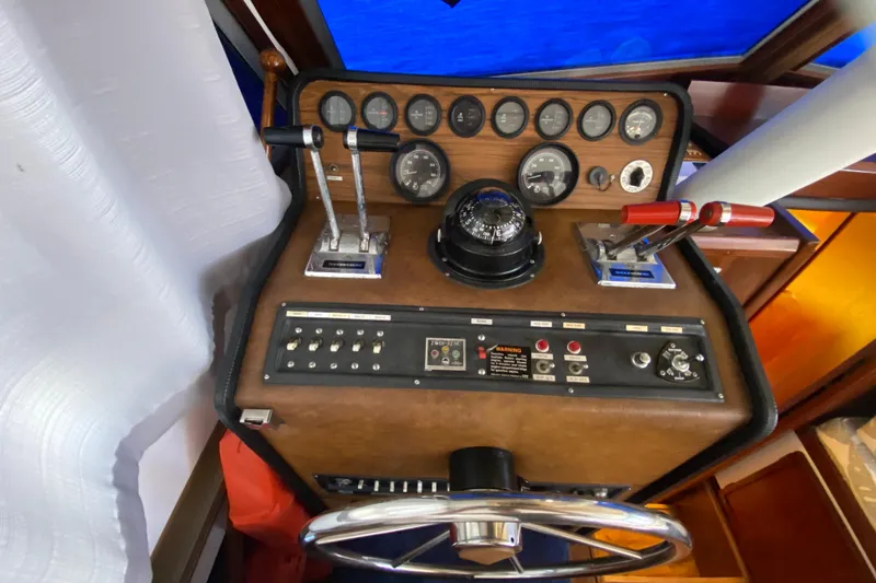 Slide: The Image of 1976 Uniflite Sport Flybridge helm with gauges, controls, and steering wheel. - 11