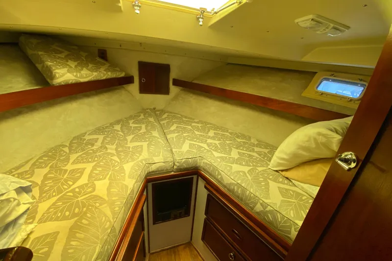Slide: The Image of 1976 Uniflite Sport Flybridge cabin with patterned bedding and wooden storage. - 13
