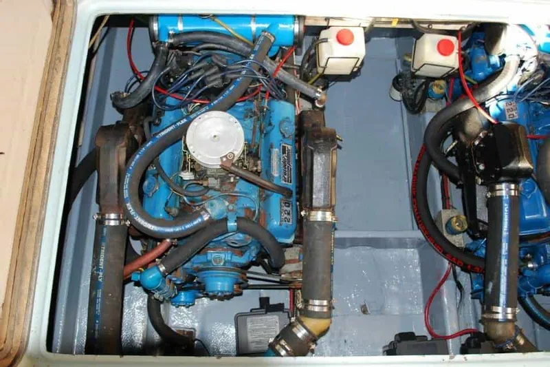 Slide: The Image of 1976 Uniflite Sport Flybridge engine compartment with visible blue marine engines and wiring. - 16