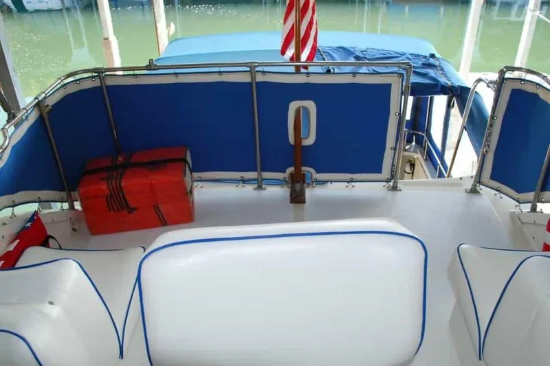 Slide: The Image of 1976 Uniflite Sport Flybridge boat interior with blue and white seating, orange life jacket, and American flag. - 18